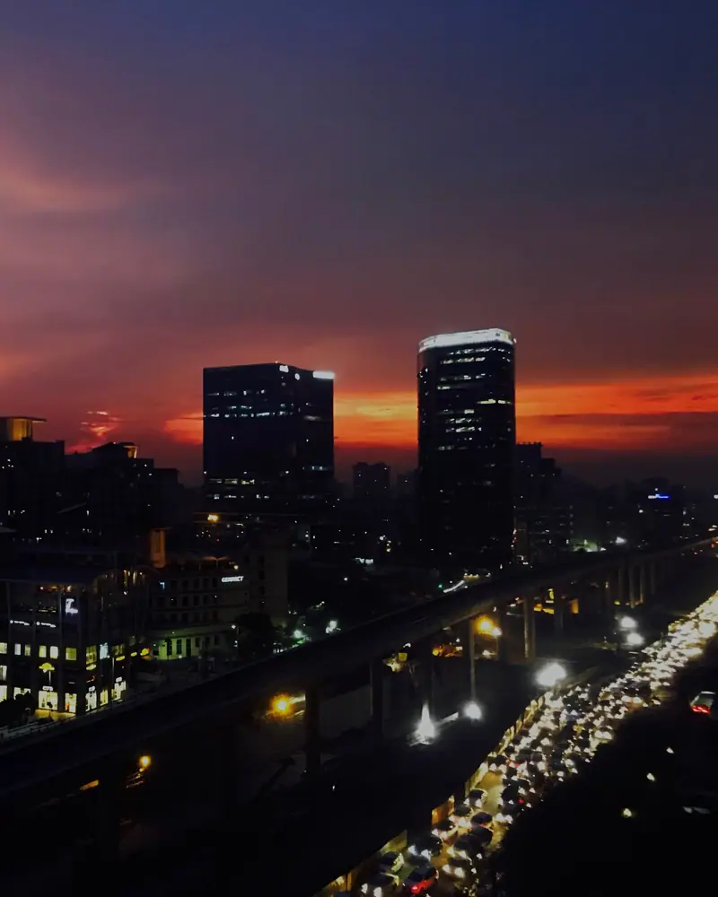 Evening skyline of towers above a lit highway in Delhi NCR
