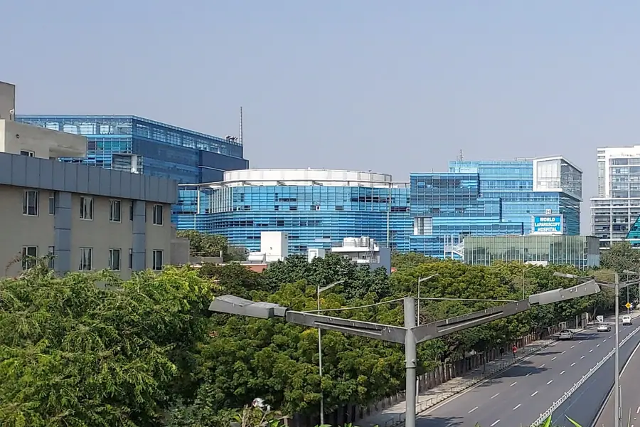 Tree-lined boulevard and glass towers in Gurugram
