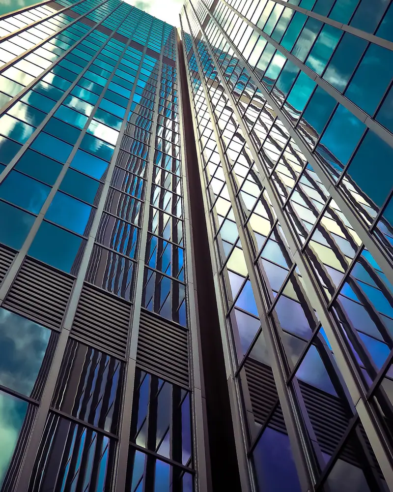 Glass towers reflecting a clouded sky